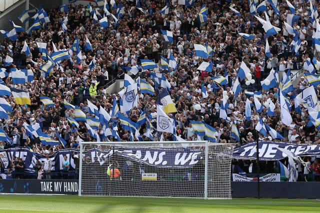 Packed stand at Deepdale with flags in the air.