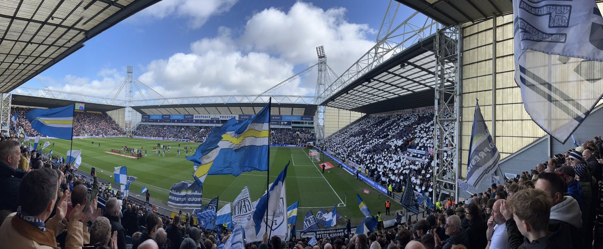 Wide stadium view of Deepdale with flags visible around the stand.