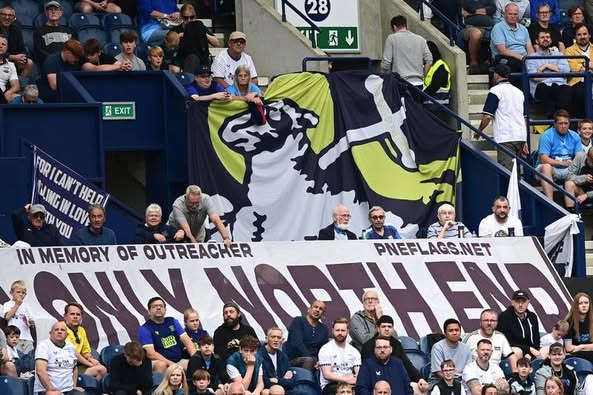 Outreacher memorial banner and lion artwork displayed in the stand.