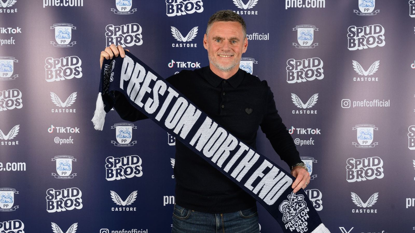 Graham Alexander holding a Preston North End scarf at his return announcement